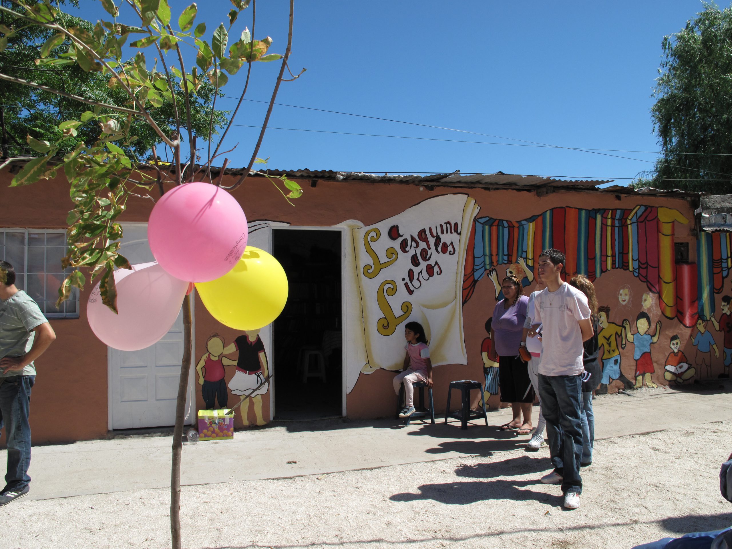 A colorful house wall with balloons and children.